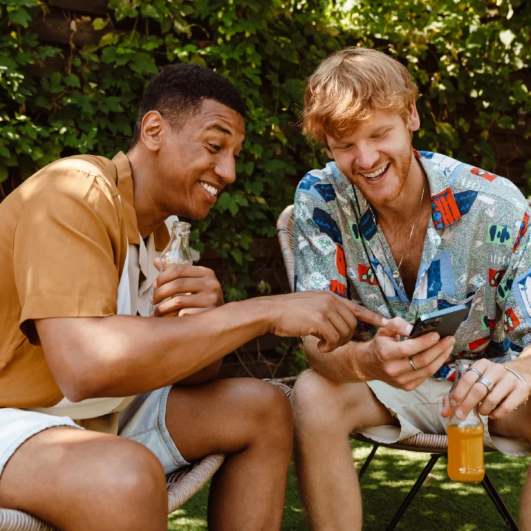 Two young men looking at a phone and referring to MyUSA Credit Union