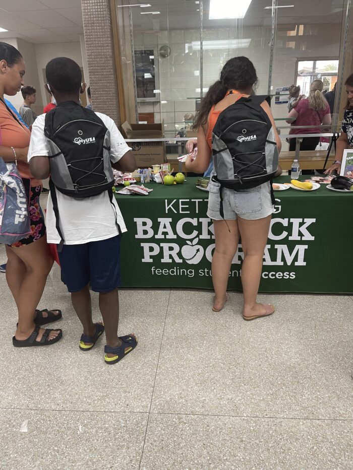 kids wearing MyUSA backpacks at a Kettering Community back to school event