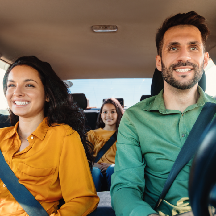 Parents driving their kid around in a car