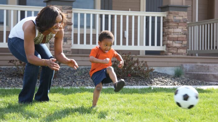 mom and son kicking a soccer ball