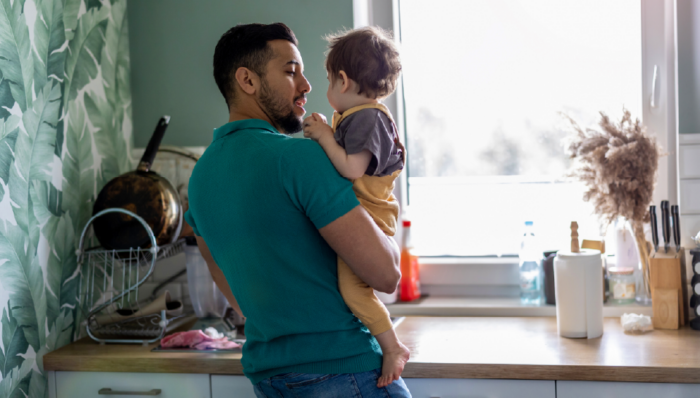 Father holding baby in a kitchen